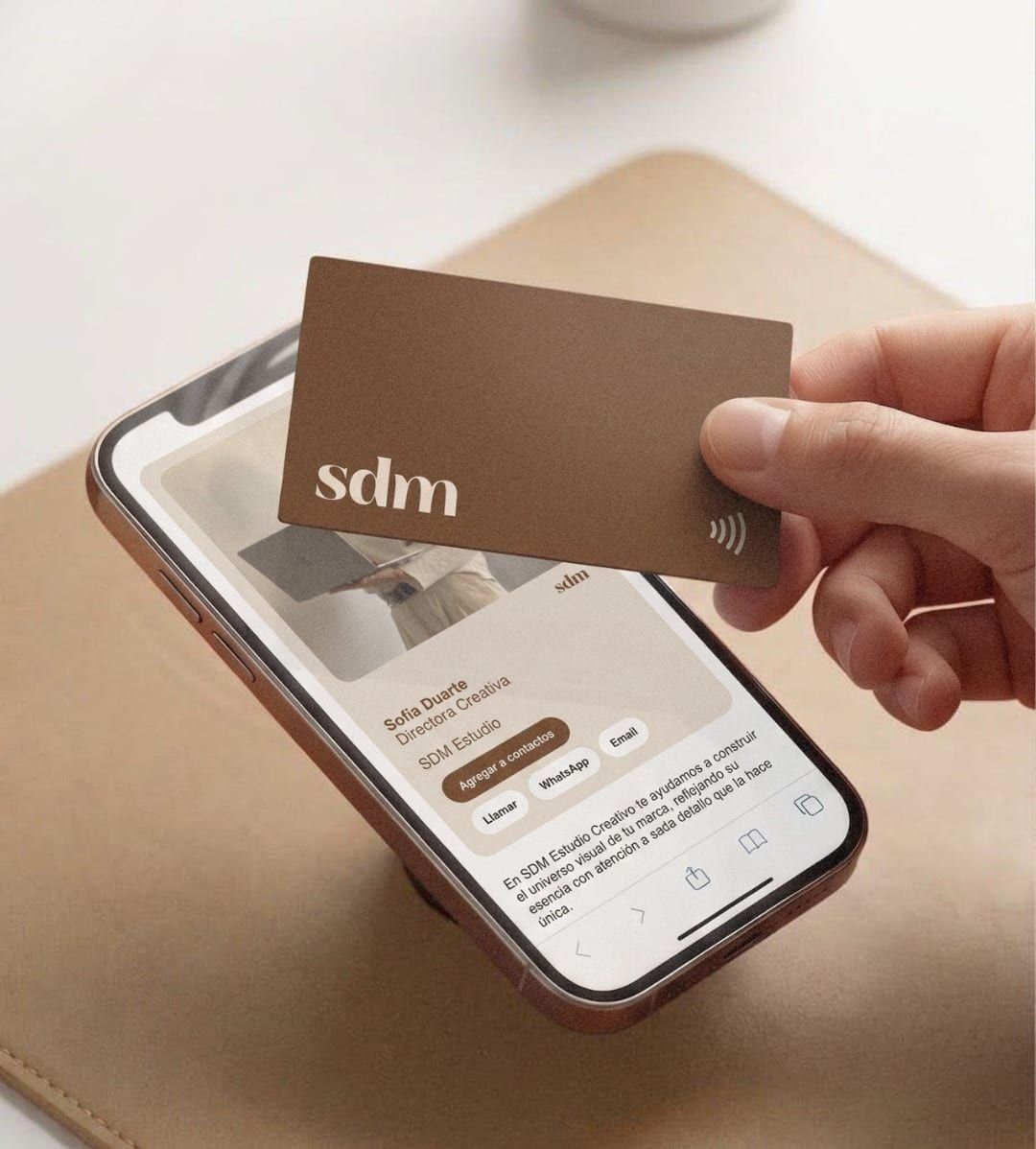 Un teléfono muestra un perfil digital SDM junto a una tarjeta impresa